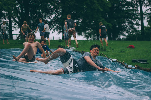 A group of campers having fun on a water slide