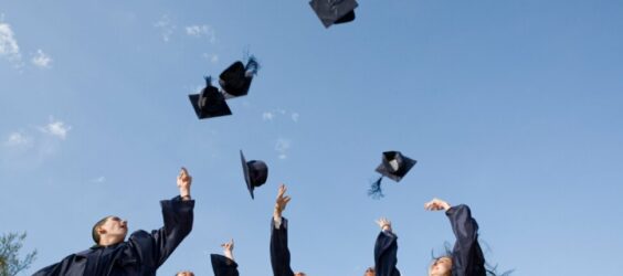 high school graduates throwing their hats in the air