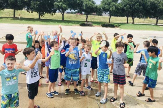 summer camp kids smiling and waving outside