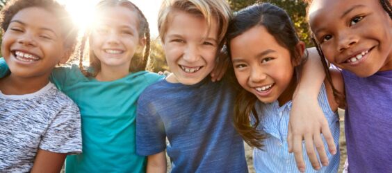 five children smiling at camera at a summer camp
