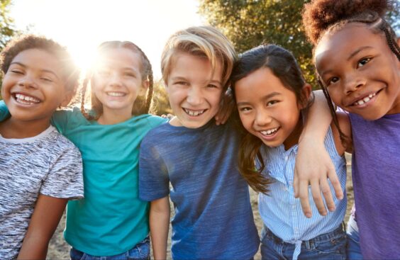 five children smiling at camera at a summer camp